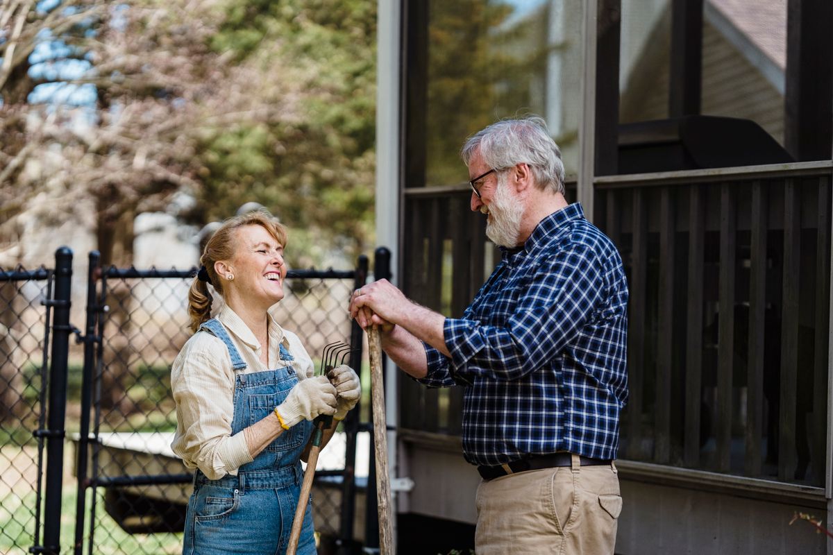 An elderly couple gardening together outdoors